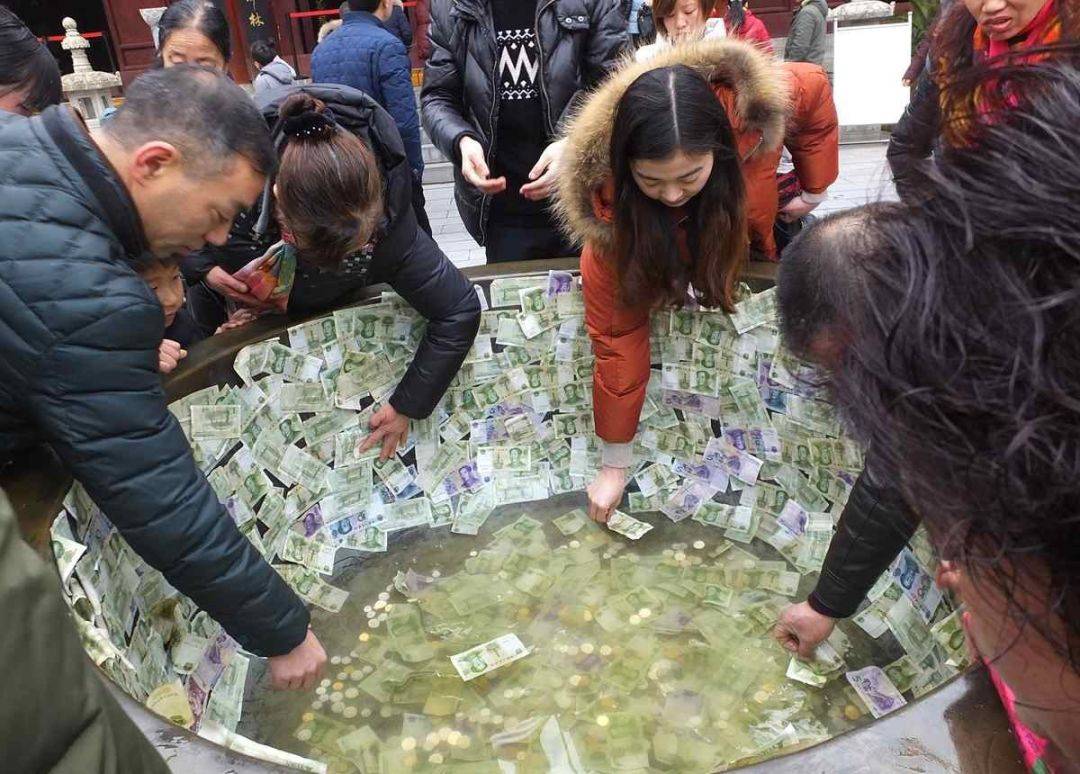 湖北宜昌香客贴钱投币,寺庙铜缸变聚宝盆   图片来源:网易新闻
