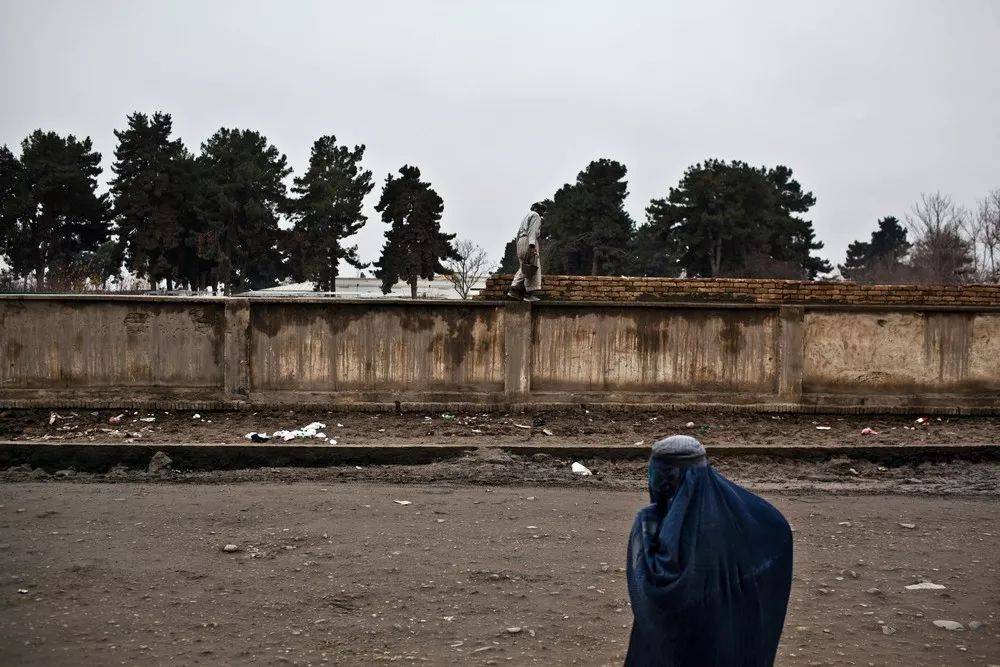 在阿富汗北部昆都士,一名当地妇女走在医院附近的路上  michael